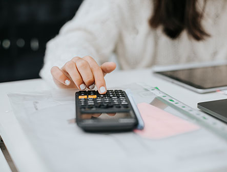 young woman preparing home budget, using laptop and calculator