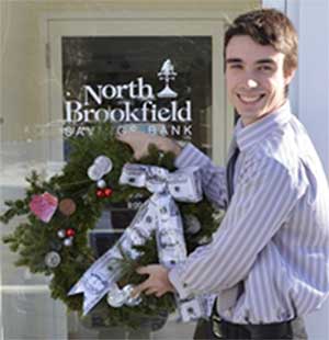 Andrew Leighton, Branch Manager, North Brookfield Savings Bank, with a wreath from students showing their appreciation for all he teaches them using the FDIC’s Money Smart for Young Adults.