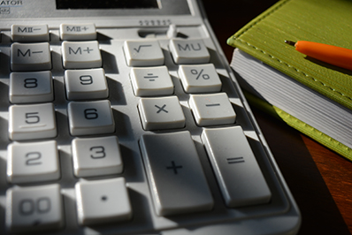 May Article Monthly Image - Picture of calculator and a notepad with a pen on top