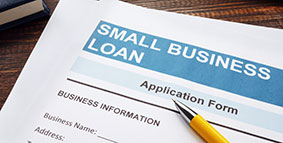 Small business loan application on a wooden surface and papers