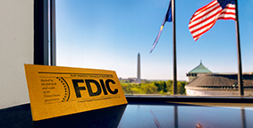 The FDIC official sign, overlooking the Washington Monument through an office window
