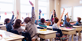 students in class raising hands